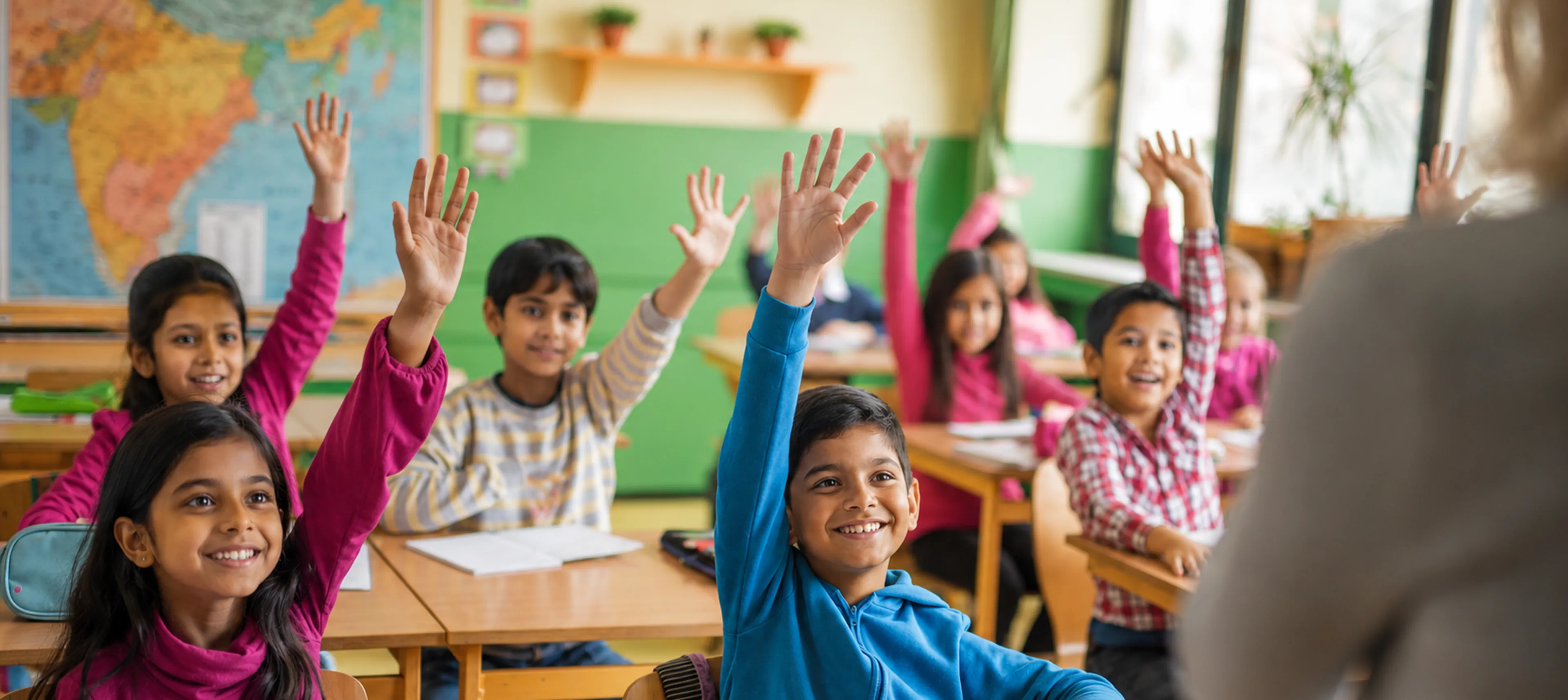 Students raising their hands in a classroom